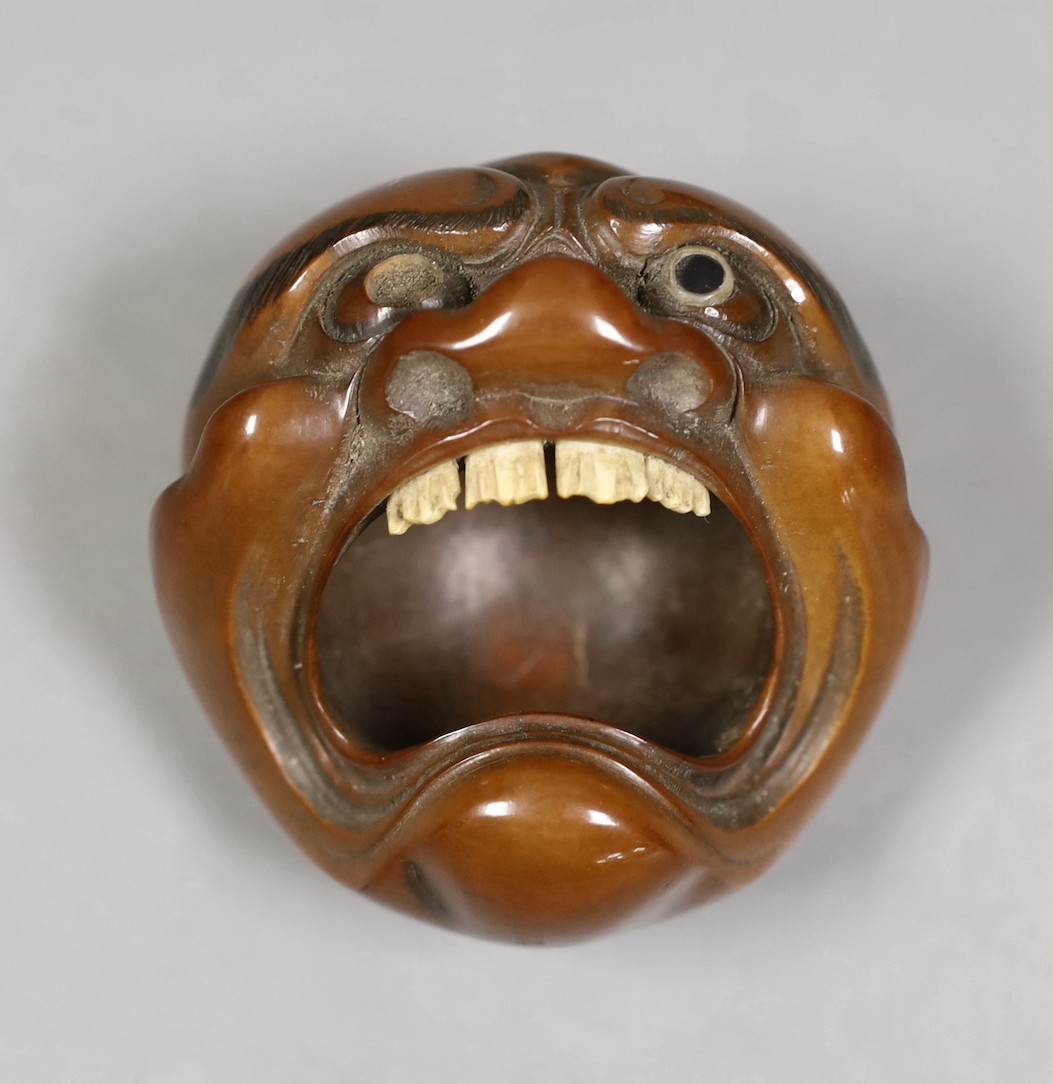 A Japanese mask nut carving wood carving, Meiji period and a netsuke of frogs, marks to bases, largest 7.5cm wide